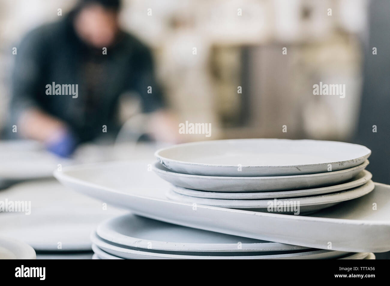 Handwerker arbeiten in der Werkstatt mit Handwerk Produkte im Vordergrund. Stockfoto