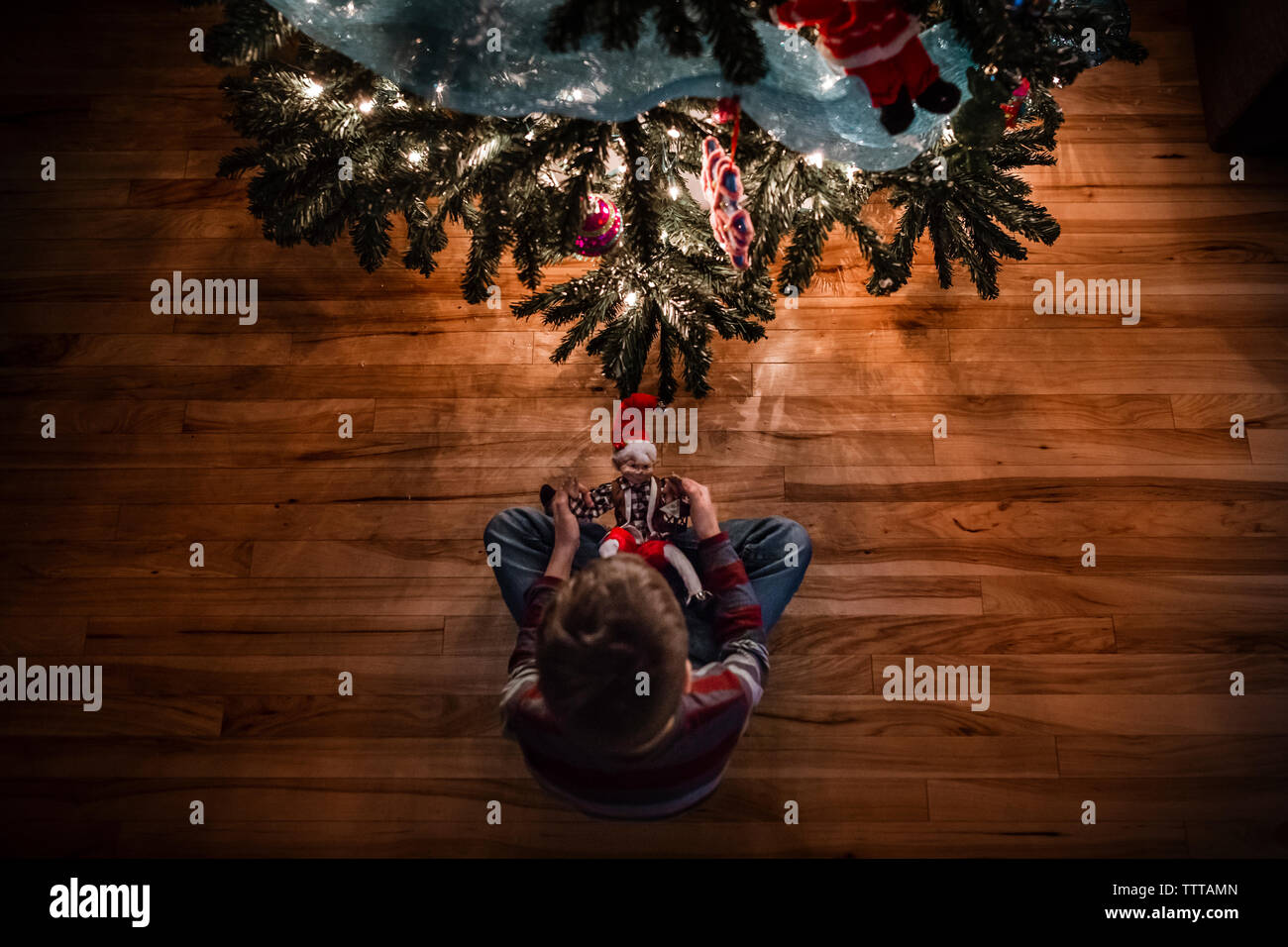 6 Jahre alter Junge und seine elf vor dem Weihnachtsbaum Stockfoto