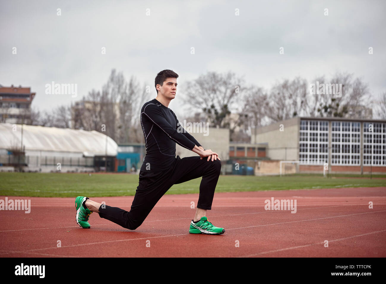 Männliche Athleten trainieren auf Sport track gegen bewölkter Himmel Stockfoto