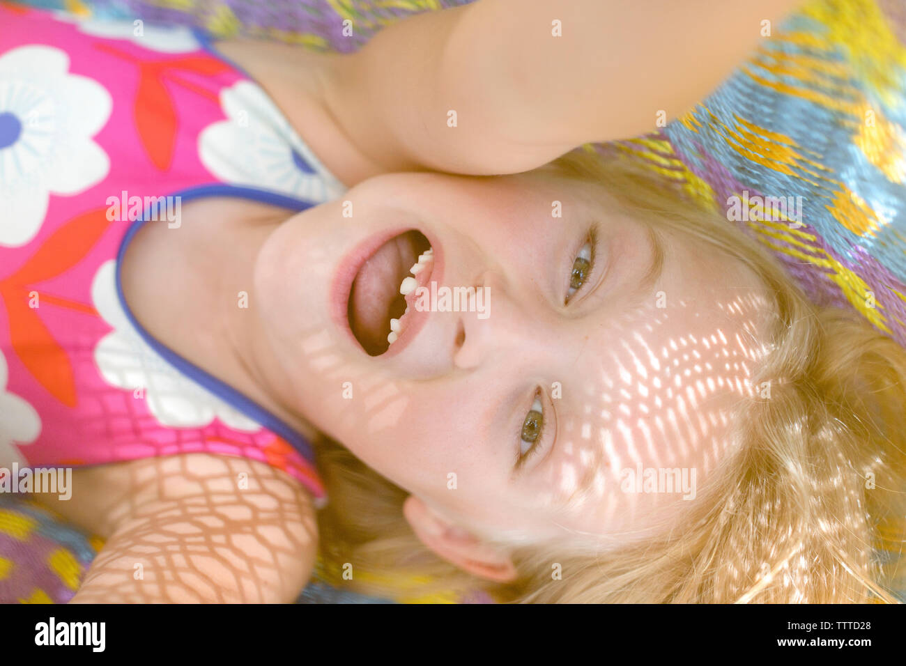 Mädchen mit fehlenden vorderen Zähne in einem farbenfrohen Hängematte Stockfoto