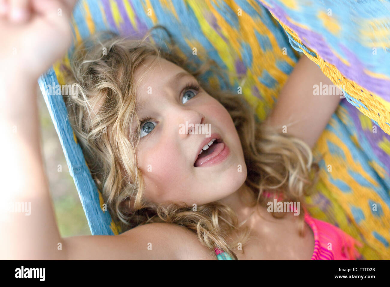 Mädchen mit blauen Augen wrpaed in einem farbenfrohen Hängematte Stockfoto