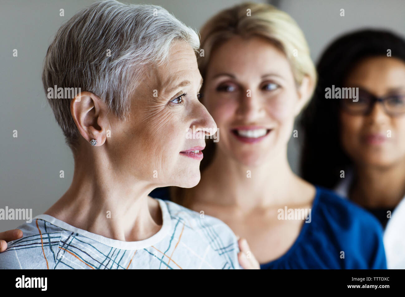 Nachdenklich, reife Frau mit Tochter und Arzt im Hintergrund Stockfoto