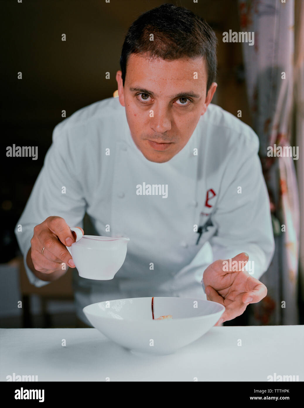 Spanien, Ezcaray, Küchenchef Francis Paniego Beschichtung ein Gericht in seinem Restaurant, El Portal De Echaurren. Stockfoto
