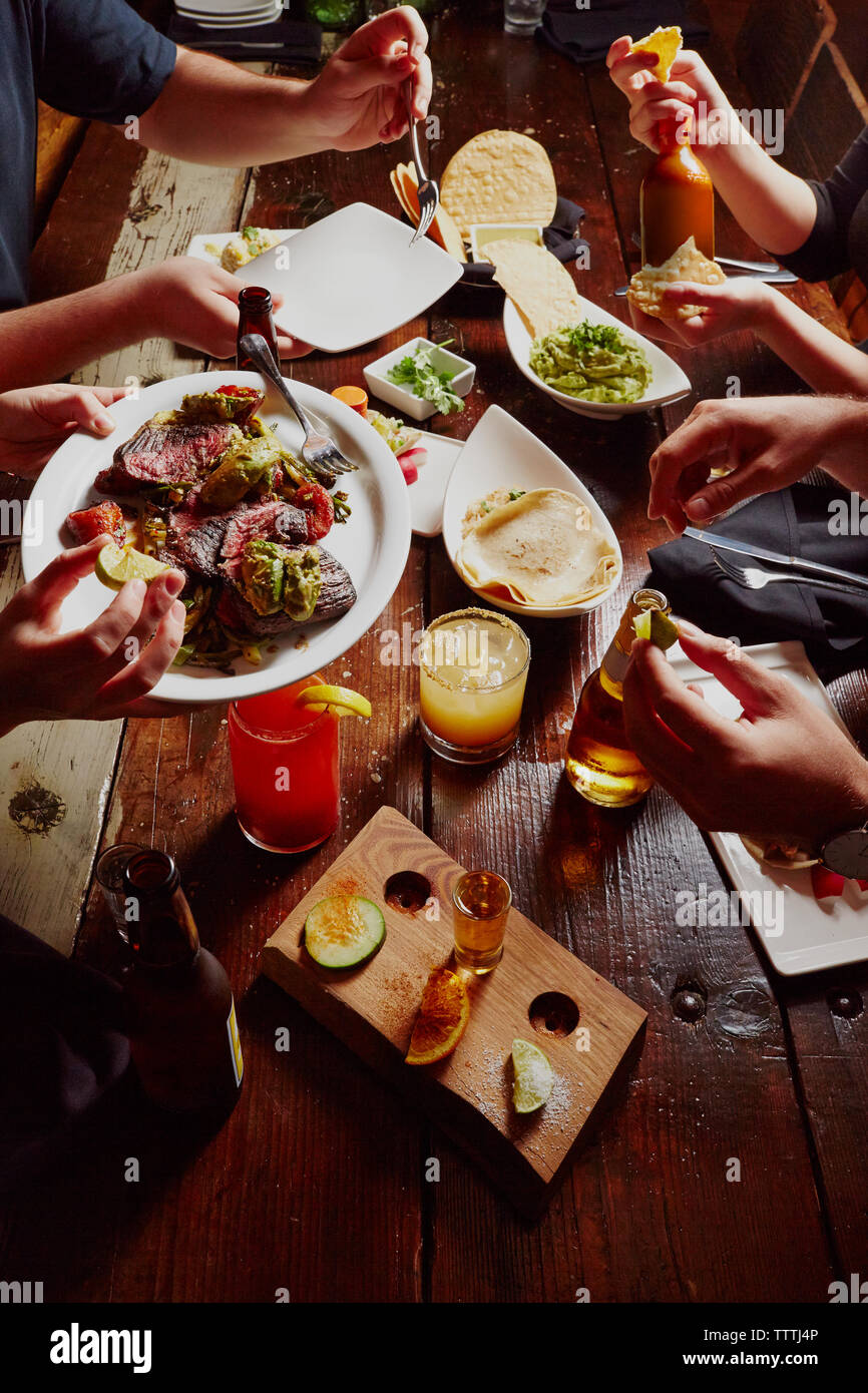 Zugeschnittenes Bild von Menschen, die Mahlzeit am Tisch Stockfoto