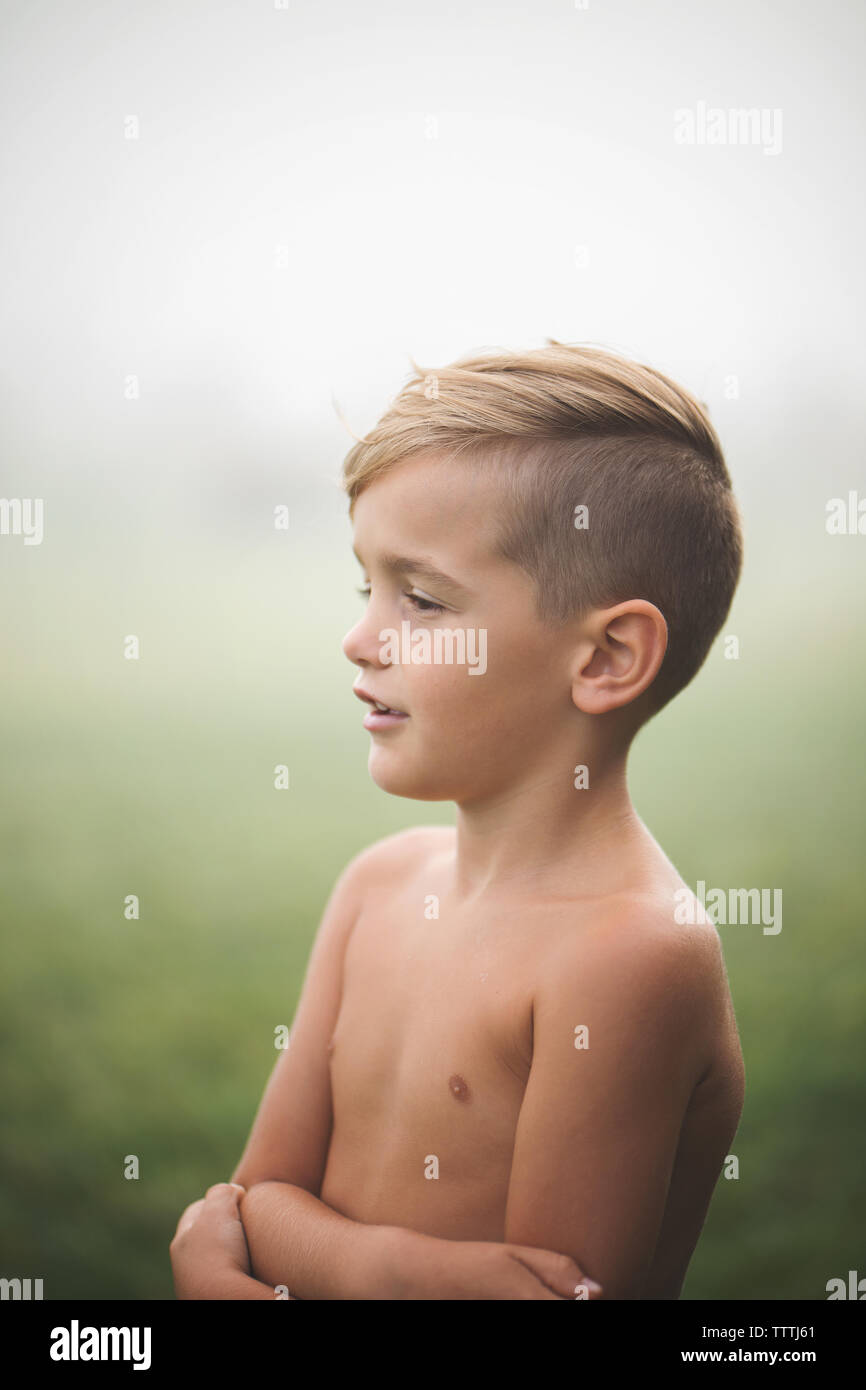 Schöner junge zeigt seine Seite Profil und fade bei Nebel. Stockfoto
