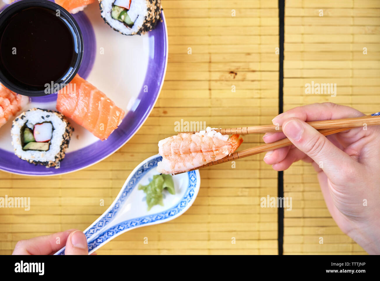 Frau mit Stäbchen erreichen für Sushi am Restaurant Fach Stockfoto