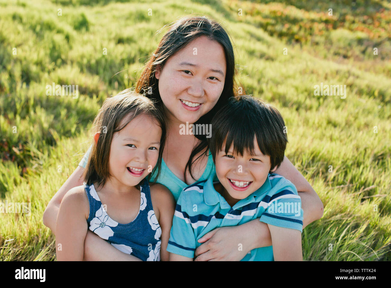 Portrait der glücklichen Mutter mit Kindern auf der Wiese Stockfoto