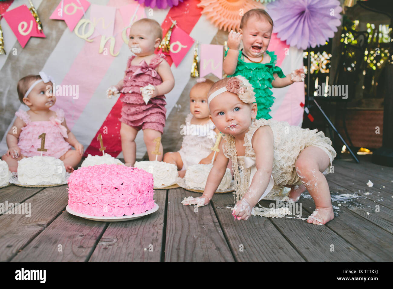 Baby Mädchen mit Geburtstag Kuchen auf Diele Stockfoto