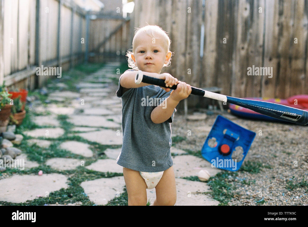Portrait von Boy holding Baseball Bat beim Stehen im Hinterhof Stockfoto