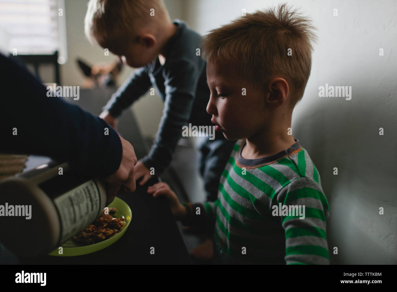 Zugeschnittenes Bild der Mutter das Essen für Kinder am Tisch Stockfoto