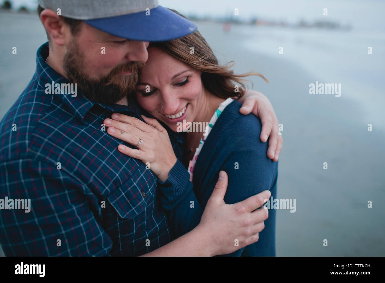 Glückliches Paar umarmt, während am Strand stehen Stockfoto