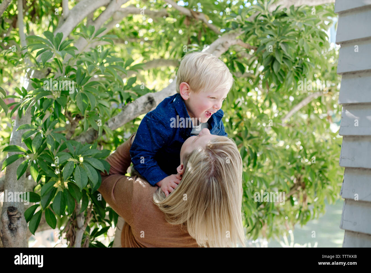 Glückliche Mutter spielt mit Sohn im Hinterhof Stockfoto