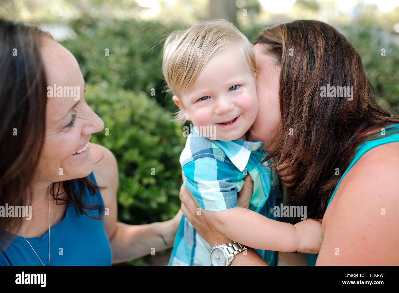 Frau auf der Suche nach Mutter küssen Sohn im Park Stockfoto