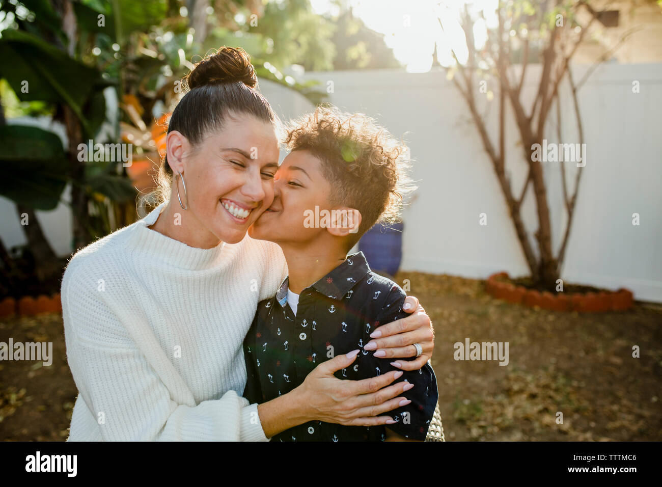Lieben Sohn küssen fröhliche Mutter im Hinterhof Stockfoto