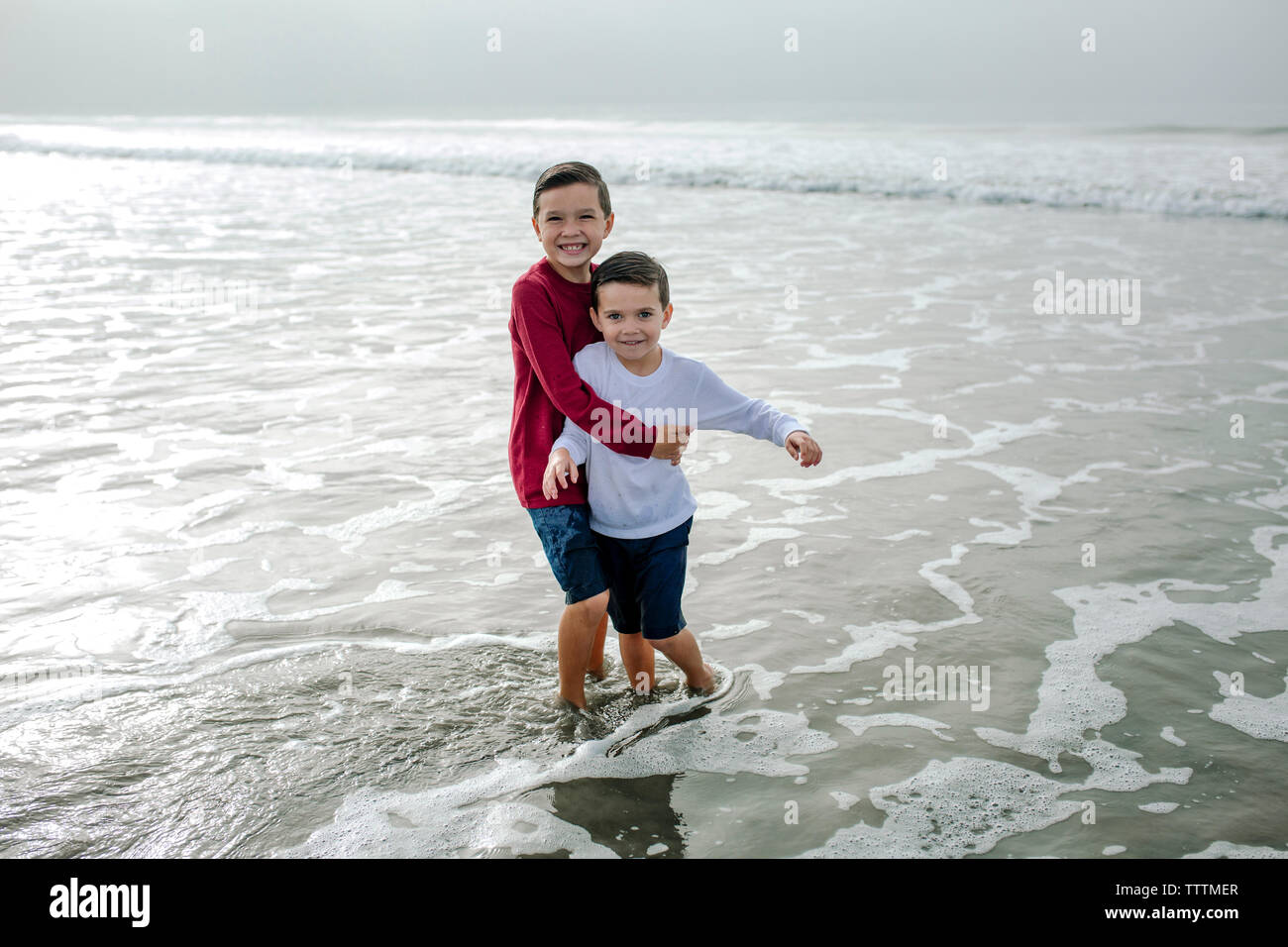 Portrait von fröhlichen Brüder spielen im Meer Stockfoto