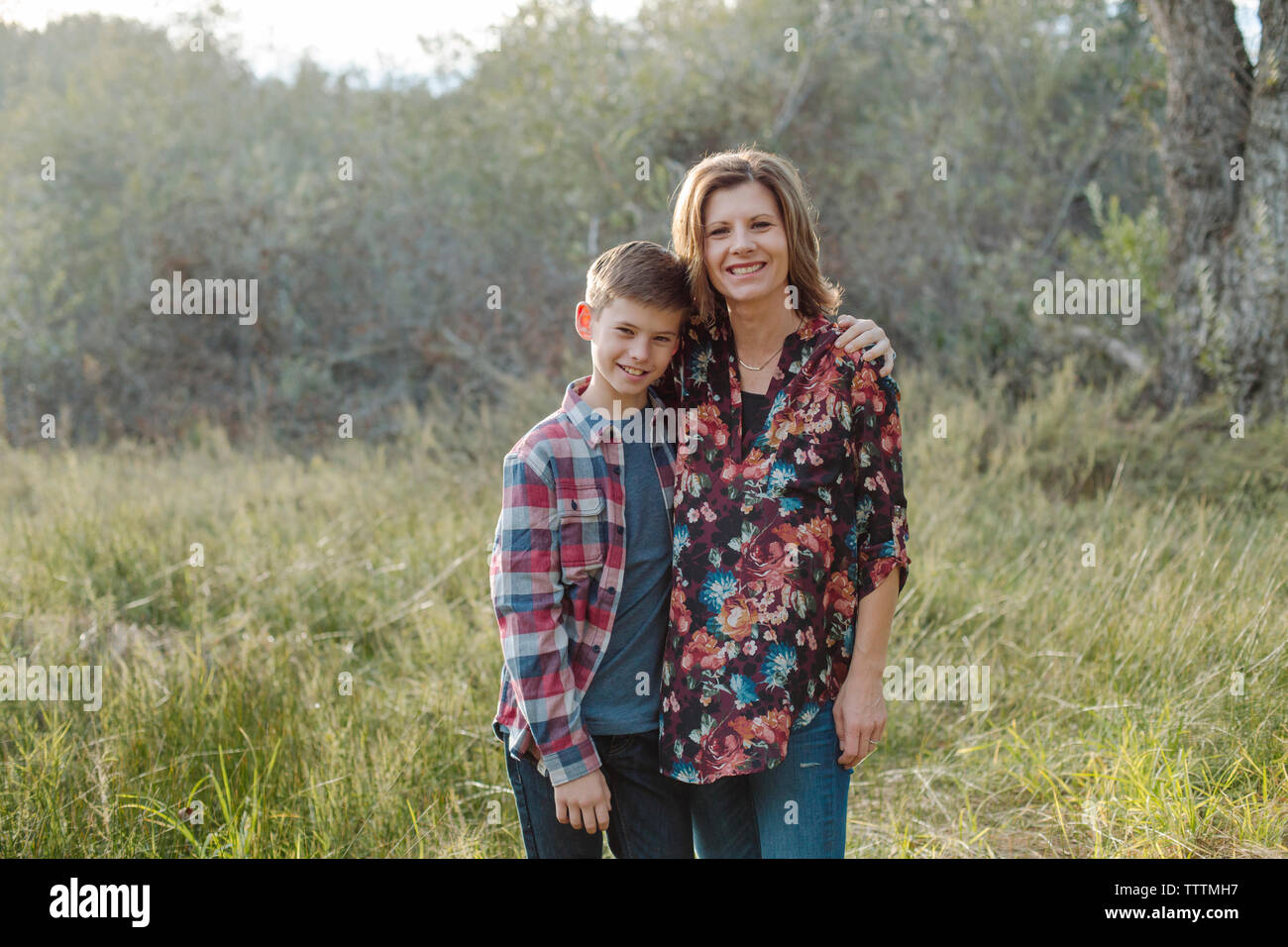 Portrait von Mutter und Sohn stehen auf Feld am Park Stockfoto