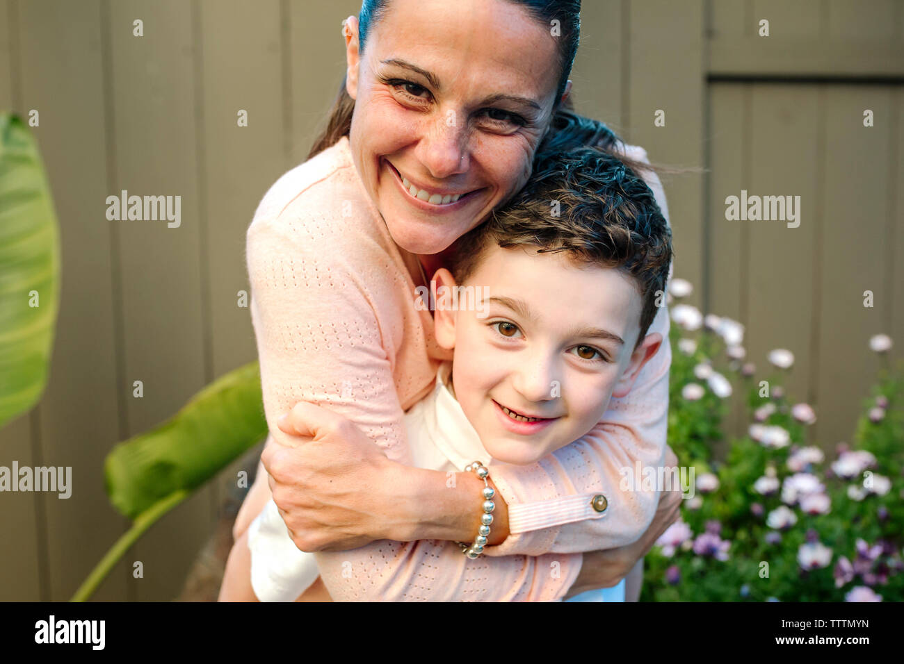 Portrait der glücklichen Mutter umarmt der Sohn beim Stehen in Hof Stockfoto