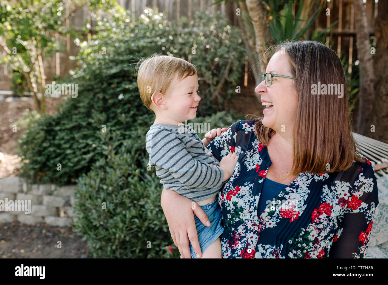 Fröhliche Mutter mit niedlichen Sohn beim Stehen im Park Stockfoto