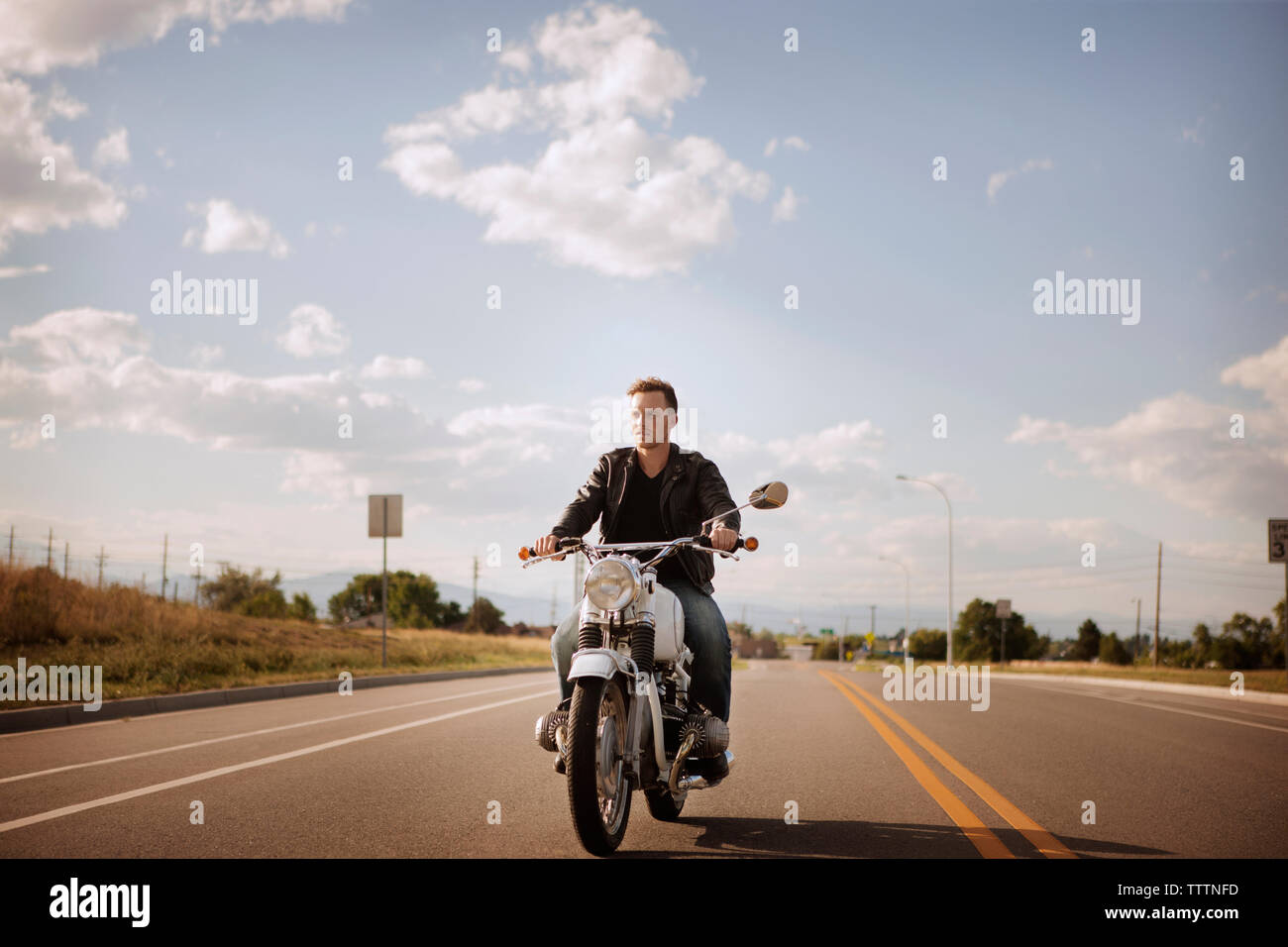 Biker reiten Motorrad auf der Straße gegen bewölkter Himmel Stockfoto