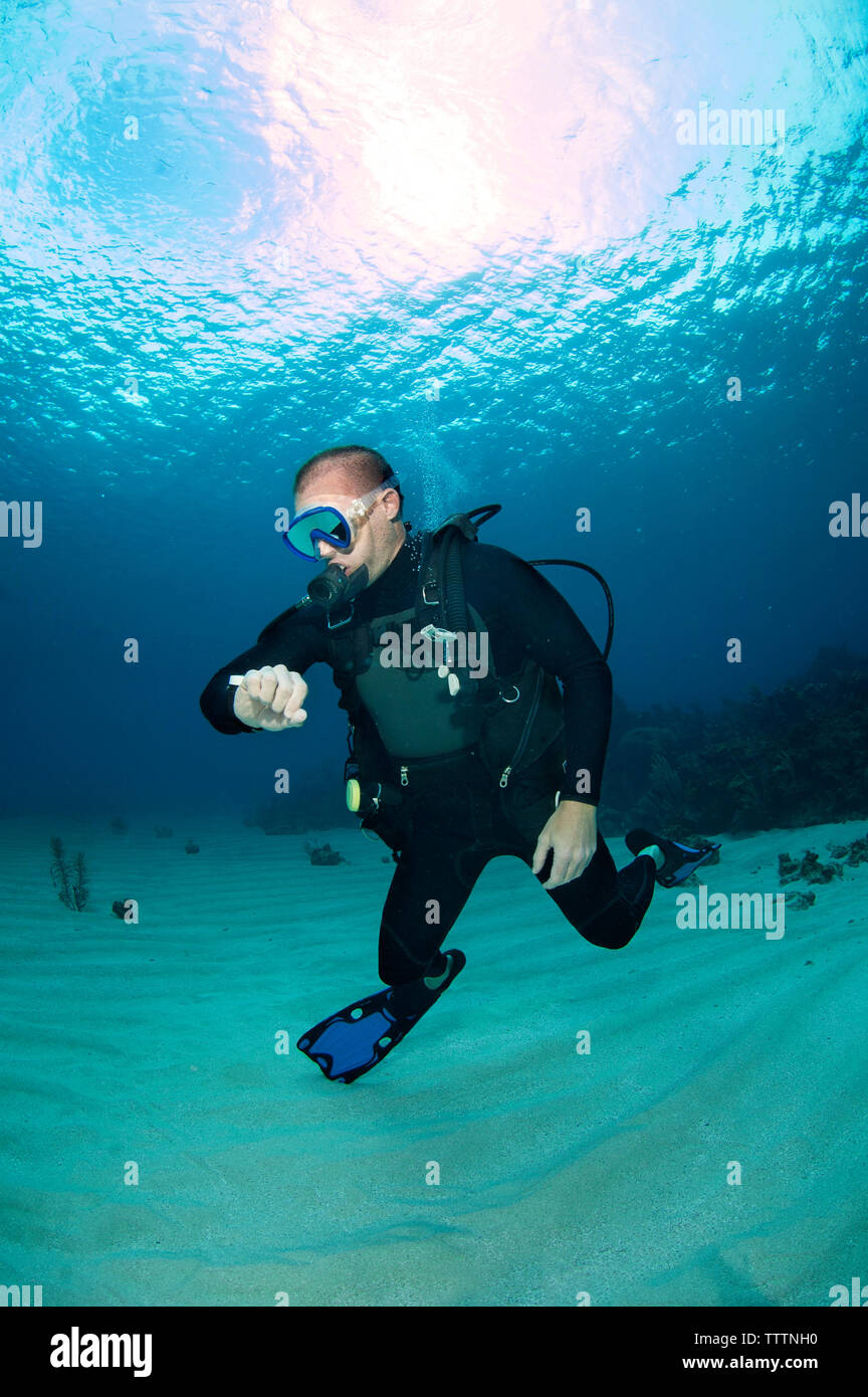 Scuba Diver Prüfung Sauerstoff Druck im Meer Stockfoto