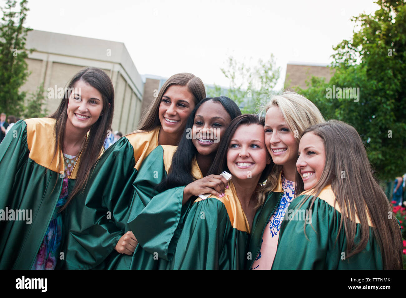 Gerne Absolvent Freunde posieren für Fotos bei Campus Stockfoto