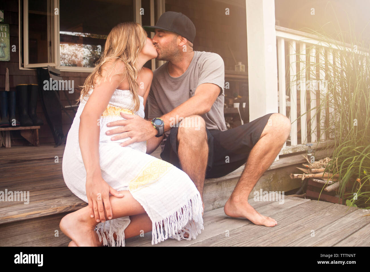 Paar Küssen, beim Sitzen auf der Veranda im Haus Stockfoto