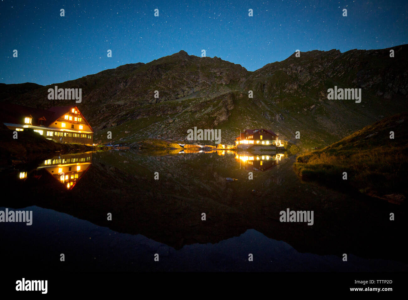 Reflexion der beleuchteten Häuser in See bei Nacht Stockfoto