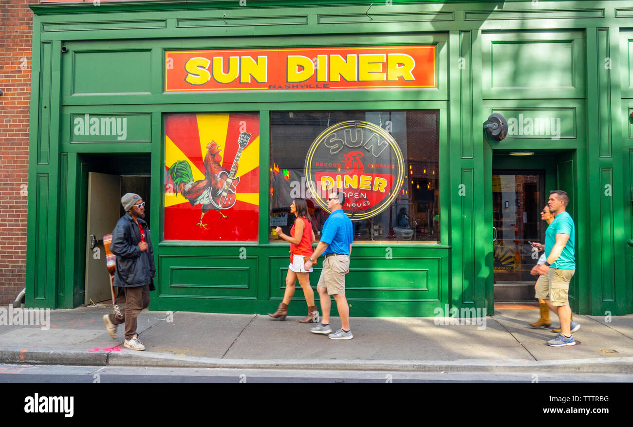 Gaukler mit einer akustischen Gitarre und Fußgänger vorbei gehen. Sun Diner am 3. Avenue Nashville Tennessee USA. Stockfoto