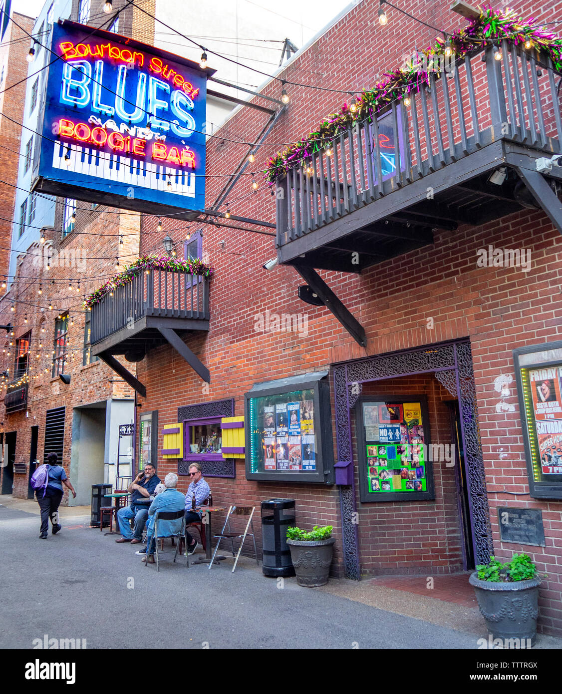 Eine Frau und drei Männer an einem Tisch sitzen außerhalb der Bourbon Street Blues und Boogie Bar bei Druckern Gasse Nashville Tennessee USA. Stockfoto