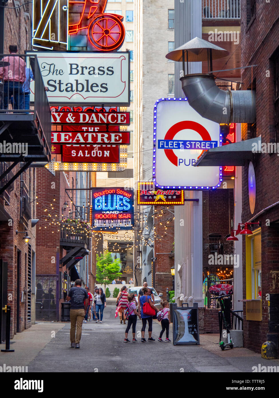 Touristen gehen unter die Leuchtreklamen an Restaurants und Veranstaltungsorten in Druckern Gasse Nashville Tennessee USA. Stockfoto