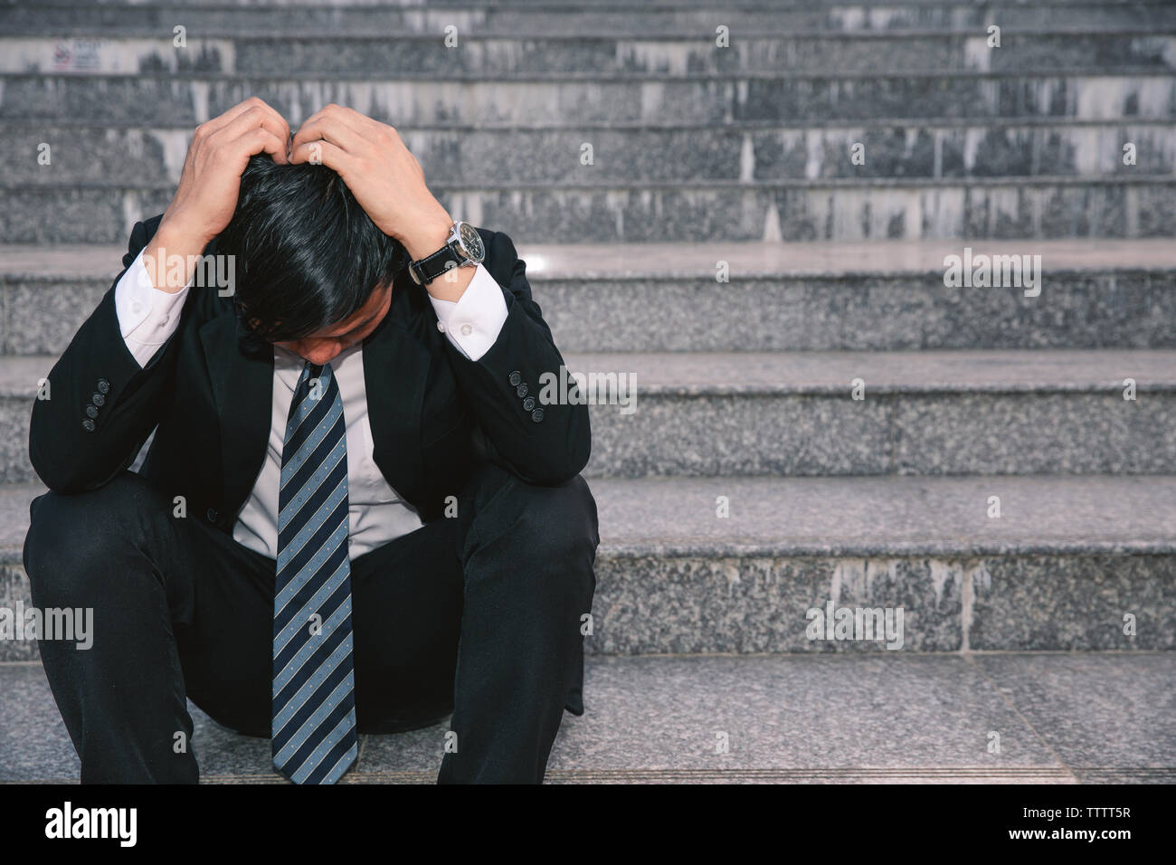 Asiatische Geschäftsleute mit Kopfschmerzen oder Migräne im Rathaus nach der Arbeit Bilder der jungen Unternehmer, die müde sind, Stress, Krise, Depression, failu Stockfoto