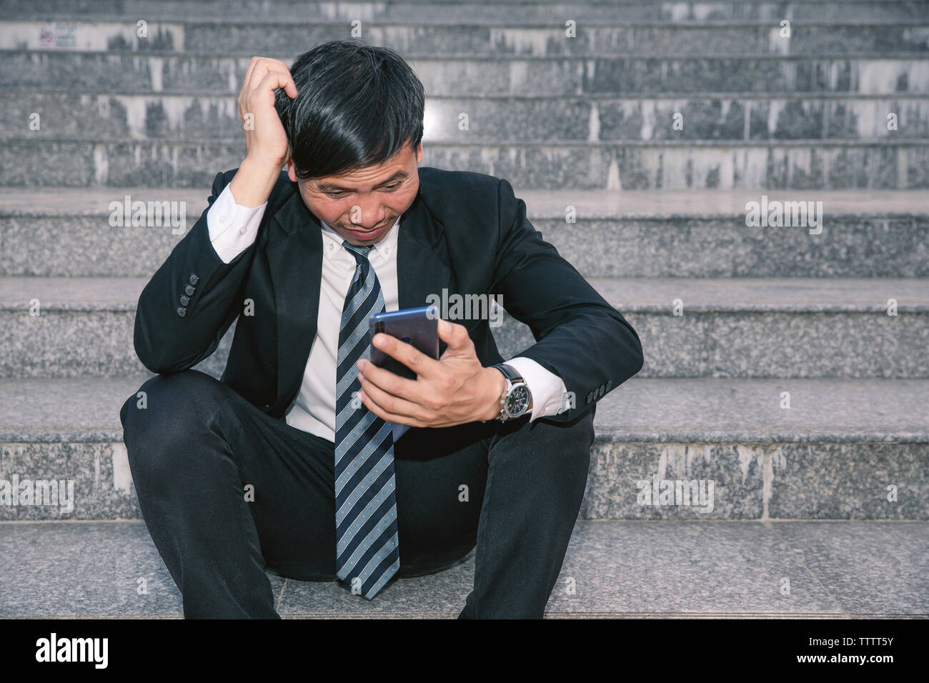 Asiatische Geschäftsleute mit Kopfschmerzen oder Migräne im Rathaus nach der Arbeit Bilder der jungen Unternehmer, die müde sind, Stress, Krise, Depression, failu Stockfoto