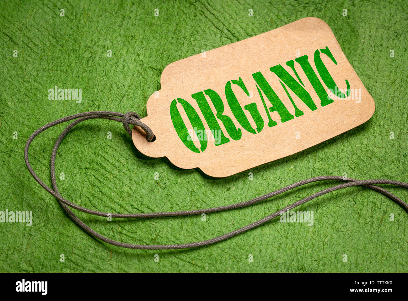 Organische Text auf einem Papier Preis Variable mit einem Garn gegen Strukturierte grüne Rinde Papier Stockfoto