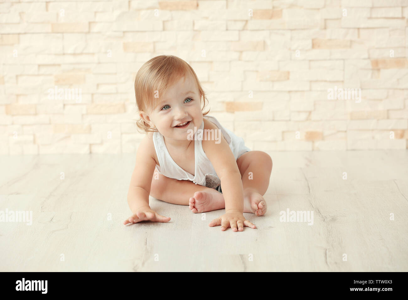 Stilvoll kleines Mädchen auf einer steinernen Wand Hintergrund posiert gekleidet Stockfoto