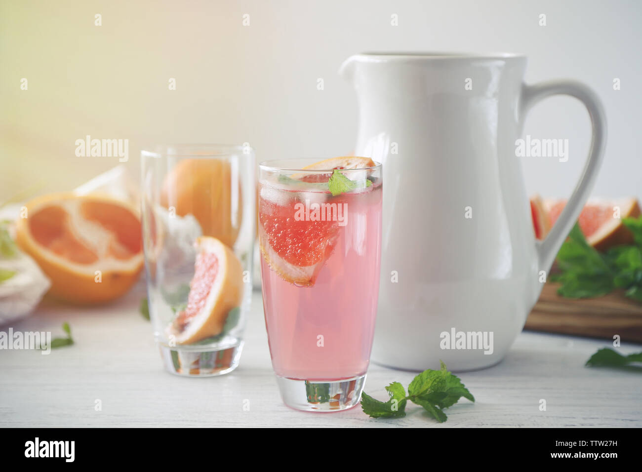 Glas grapefruit Limonade und Kanne auf weiße Holztisch Stockfoto