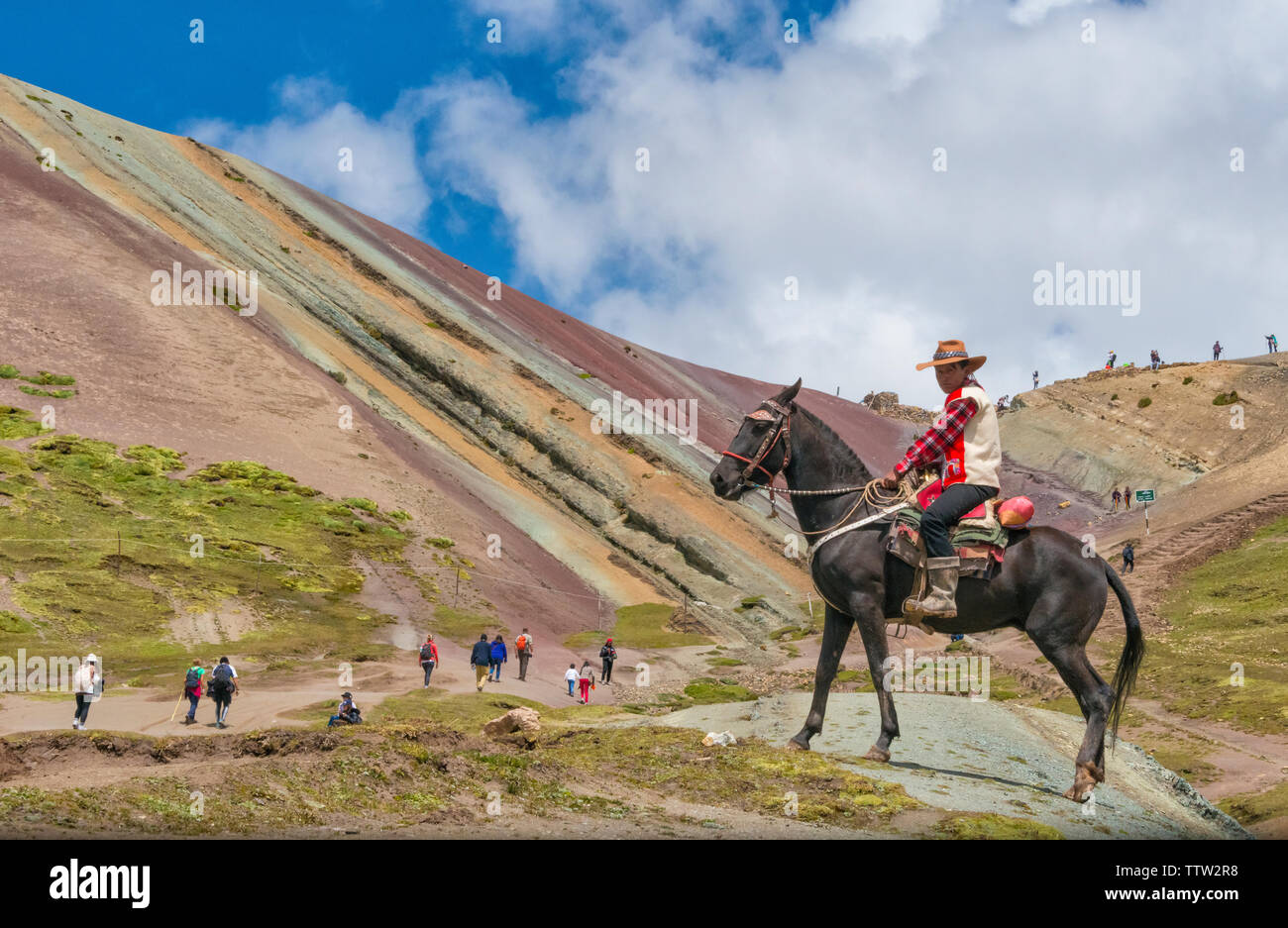 Quechua Mann reiten auf Pferd in Rainbow Mountain (Vinicunca), Cusco Region, Peru Stockfoto