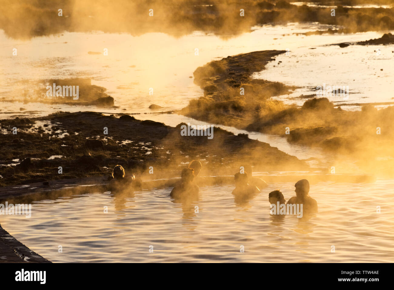 Touristen in einer heißen Quelle in der Morgendämmerung, Sol de Manana (Morgensonne), Potosi, Bolivien Stockfoto