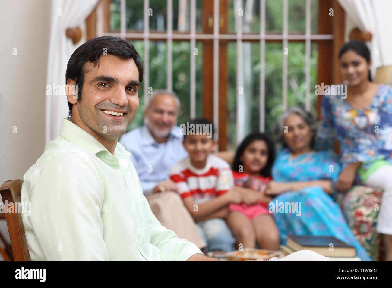 Porträt eines Mannes mit seiner Familie im Hintergrund lächelt Stockfoto