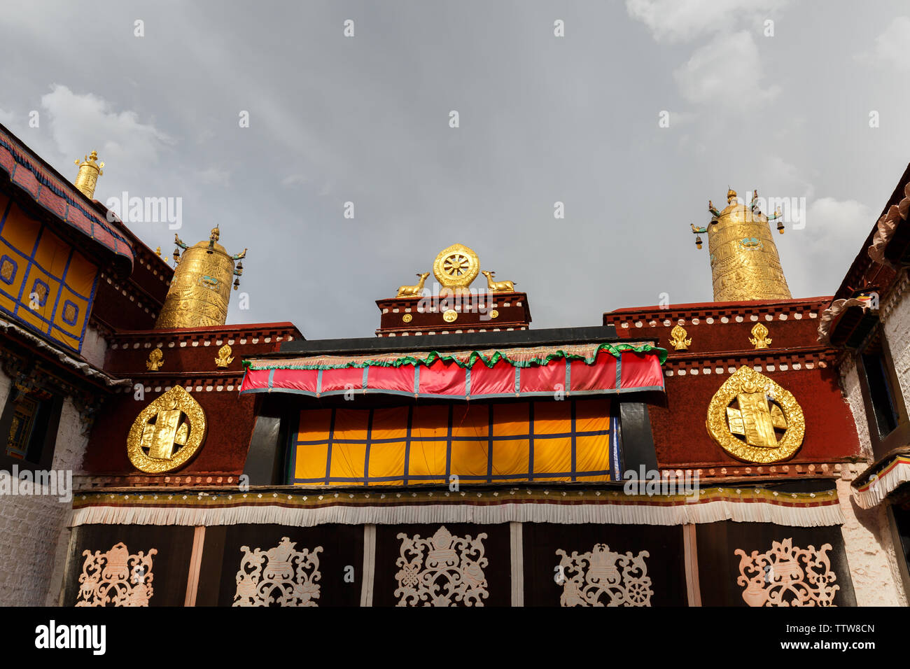 Ansicht auf dem Dach des Jokhang Tempel. Ein Dharma Rad mit zwei Hirsche und Gebetsmühlen Krone die berühmten Tempel. Tibetische buddism, Ornamente, buddhistische Kunst. Stockfoto
