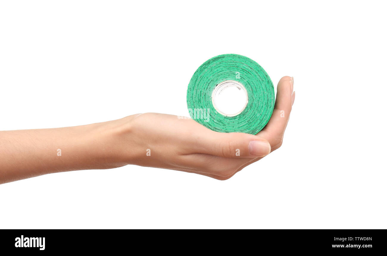 Weibliche Hand, die eine spezielle Physio Tape Rolle auf weißem Hintergrund Stockfoto