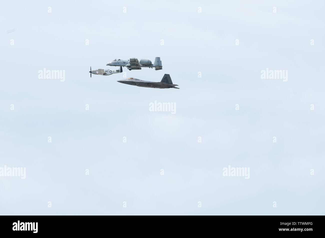 Eine P-51 Mustang, A-10 Thunderbolt II und F-22 Raptor fliegen in Formation über Whiteman Air Force Base, Missouri, am 16. Juni 2019. Das Flugzeug ein Erbe Demonstration während der 2019 Flügel über Whiteman für Luft- und Raumfahrt zeigen. (U.S. Air Force Foto: Staff Sgt. Kayla Weiß) Stockfoto