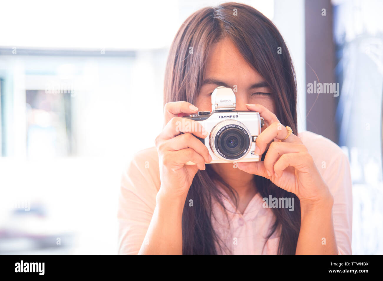 Junge schöne asiatische Frau die Foto im Freien mit DSLR Digitalkamera. Junge fröhliche weibliche Touristen Spaß im Coffee Shop. Lifestyle portrai Stockfoto