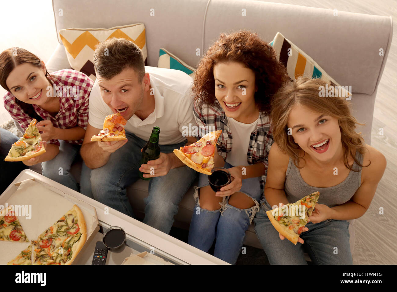 Freunde sitzen auf der Couch und Essen lecker Pizza Stockfoto