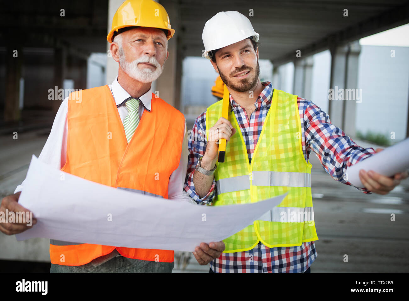 Zuversichtlich Team von Architekten und Ingenieuren zusammen Arbeiten auf der Baustelle Stockfoto