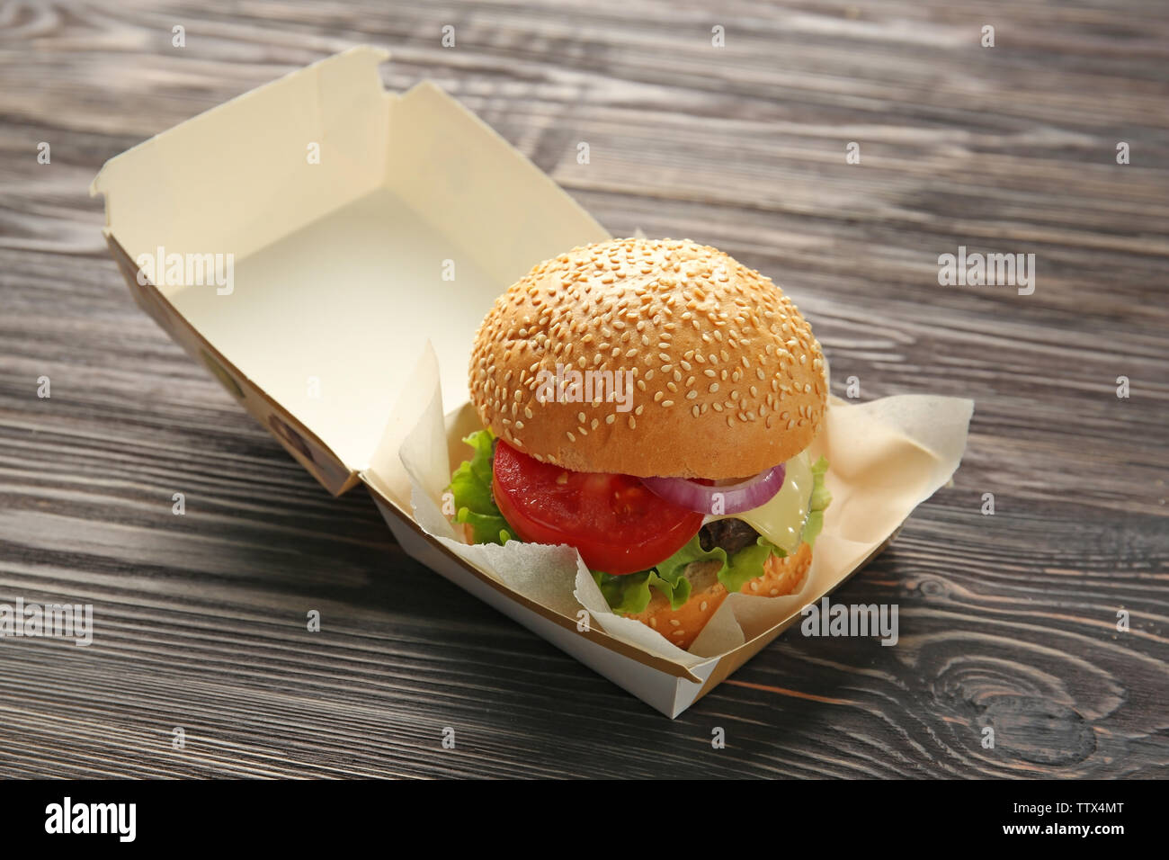 Leckere Cheeseburger im Karton auf Holz- Hintergrund Stockfoto
