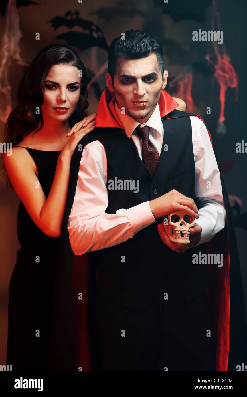 Junge Leute gekleidet wie Vampire für Halloween Party, auf dunklem Hintergrund Stockfoto