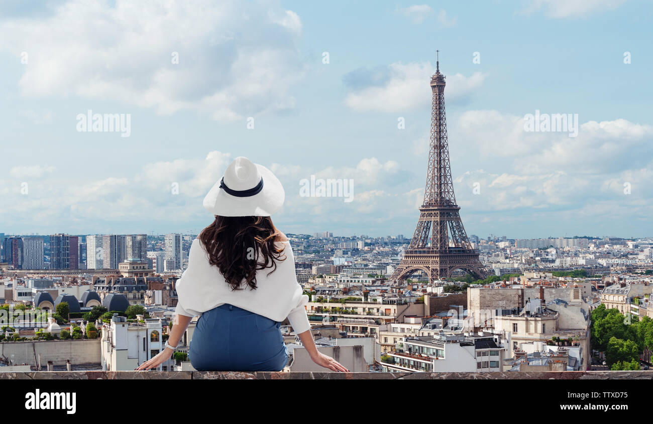 Unterwegs in Europa, junge Frau im weißen Hut am Eiffelturm suchen, Wahrzeichen und Reiseziel in Paris, Frankreich im Sommer Stockfoto