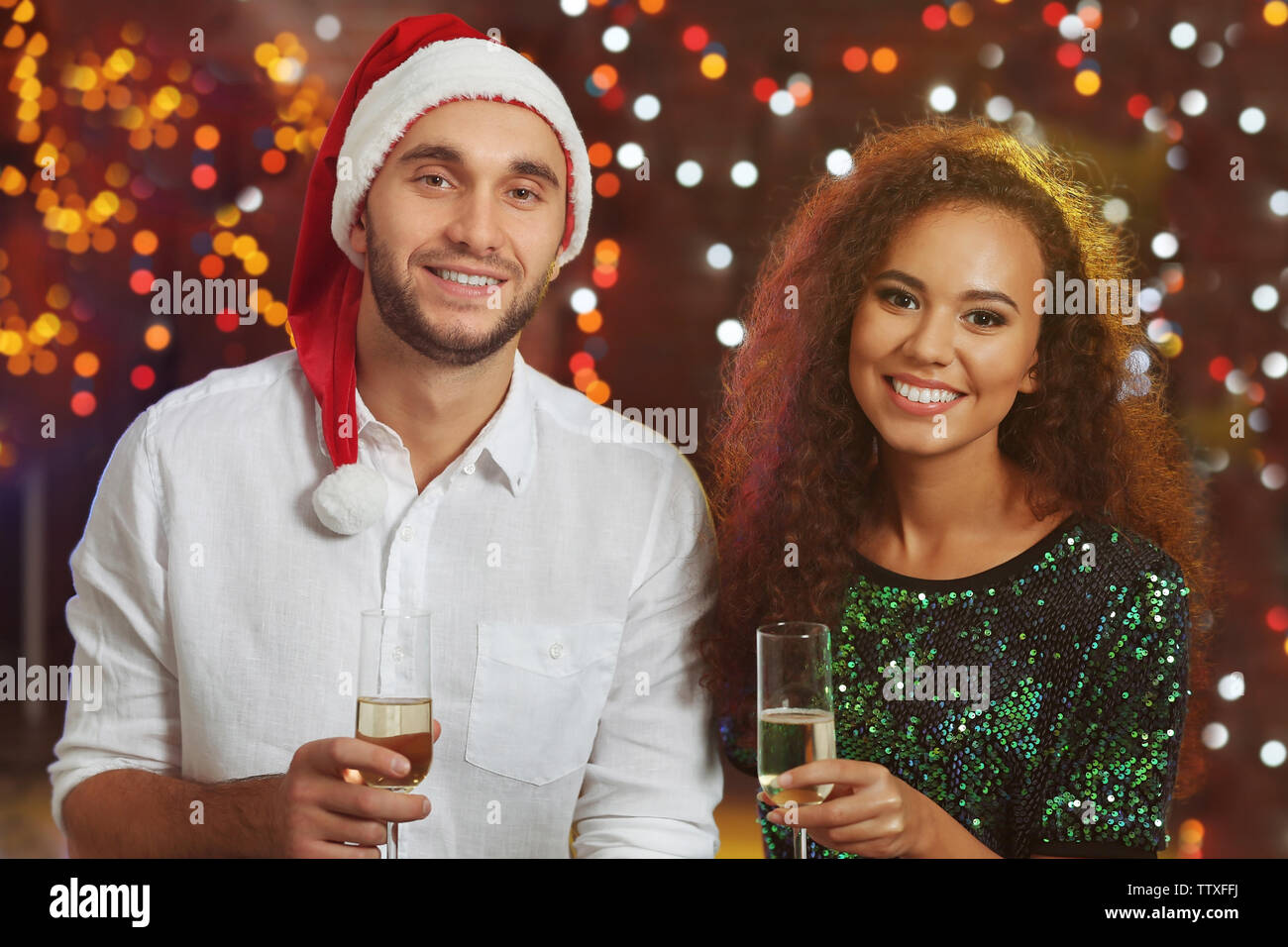 Junger Mann und Frau mit Brille Champagner an der Weihnachtsfeier Stockfoto