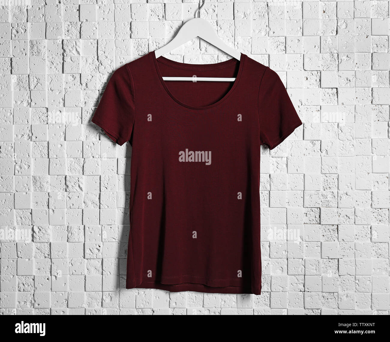 Leere maroon-t-shirt gegen Licht strukturierten Hintergrund Stockfoto