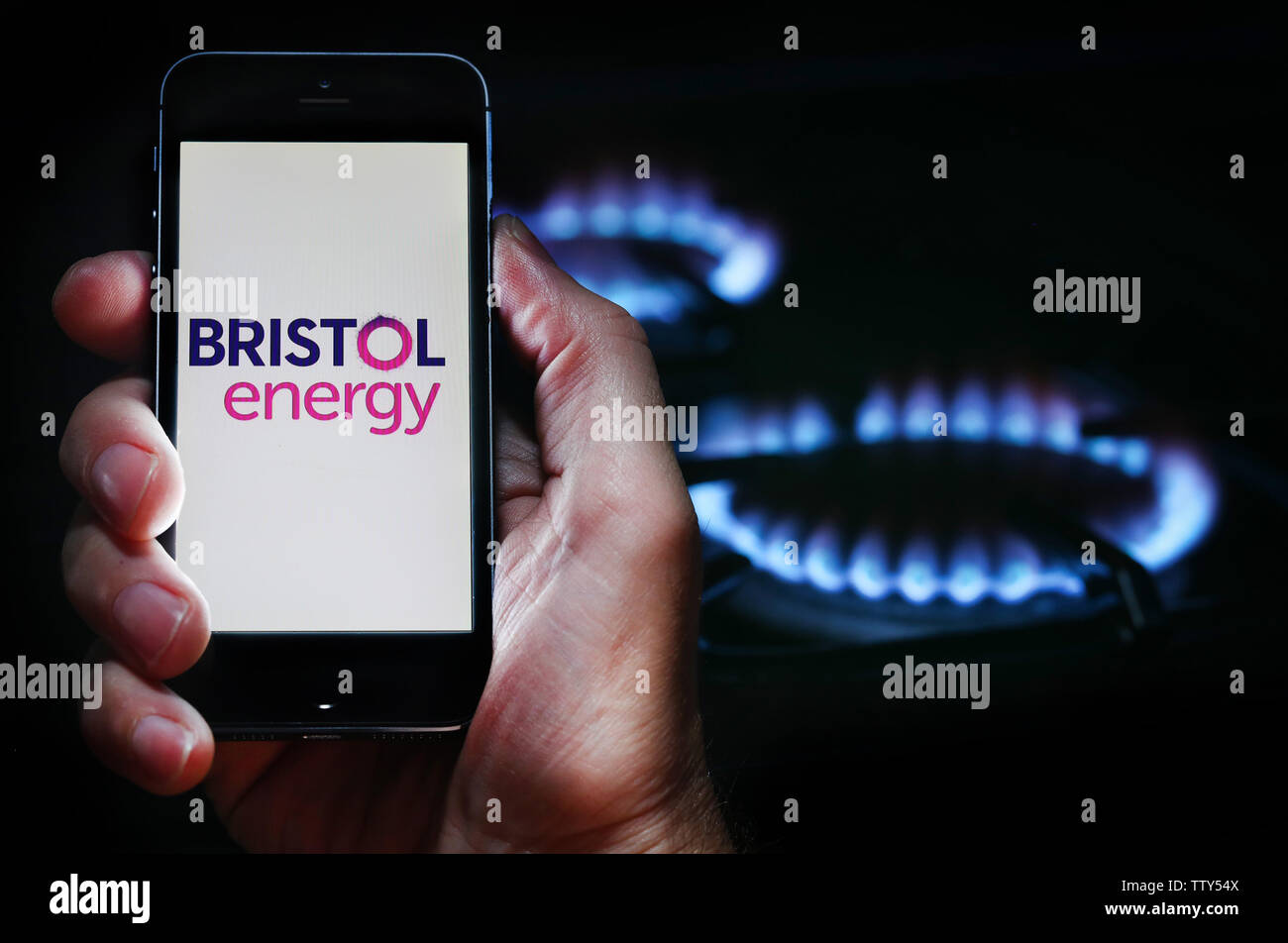 Ein Mann auf der Website Logo auf der Suche nach Energie Firma Bristol Energie auf seinem Mobiltelefon vor seinem Gaskocher (Editorial nur verwenden) Stockfoto
